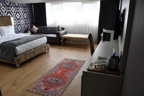 a bedroom with a bed and a couch and a living room at HMZ LUXURY HOTEL in Çekme