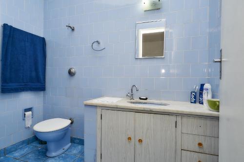 Baño azul con aseo y lavamanos en Deck Hostel Taquaral, en Campinas