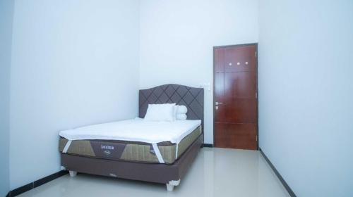 ein Schlafzimmer mit einem Bett in einem Zimmer mit einer Tür in der Unterkunft Villa Cendana Syariah Private Pool by Masterpiecevilla in Batu