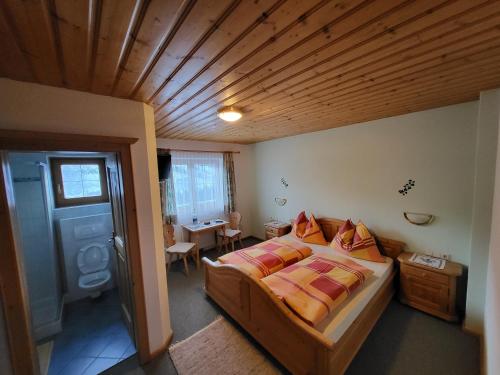 a bedroom with a bed and a wooden ceiling at Hagauhof in Kirchberg in Tirol