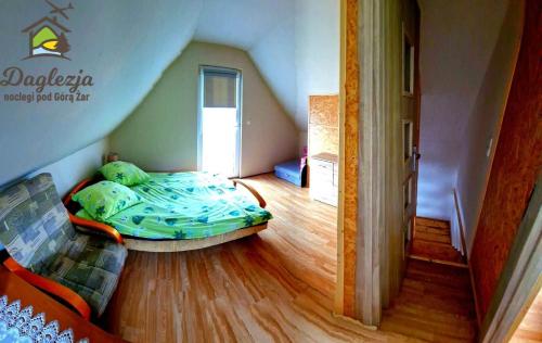 a bedroom with a bed in the corner of a room at Noclegi Daglezja pod Górą Żar in Międzybrodzie Żywieckie