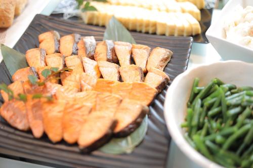 a plate of food with carrots and a bowl of green beans at Urban Hotel Kyoto Gojo Premium in Kyoto