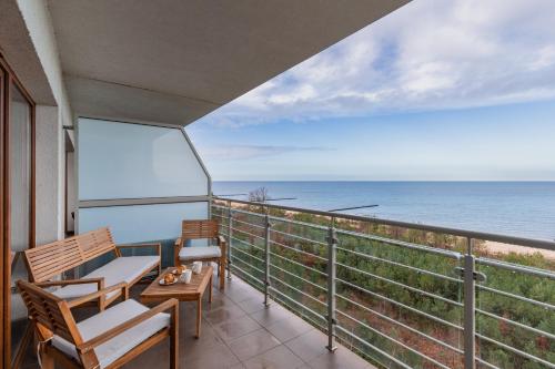 a balcony with chairs and a table and the ocean at Apartamenty Porta Mare by Renters in Dziwnówek