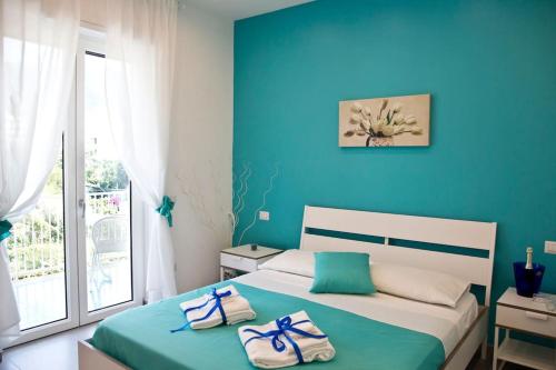 La Delizia - Sorrento في سورينتو: غرفة نوم زرقاء مع سرير عليه مناشف