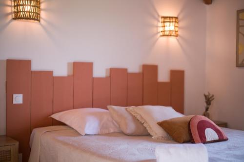 a bedroom with a large wooden headboard on a bed at Hôtel - Restaurant U Santu Petru in Saint-Florent