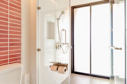 a bathroom with a shower and a glass door at Sand Dunes Chaolao Beach Resort in Chao Lao Beach