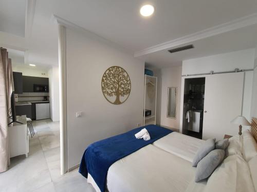 1 dormitorio con 1 cama grande y cocina en Apartamentos Los Angeles, en Sevilla