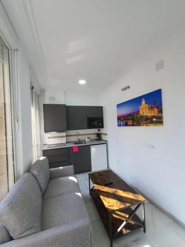 a living room with a couch and a coffee table at Apartamentos Los Angeles in Seville