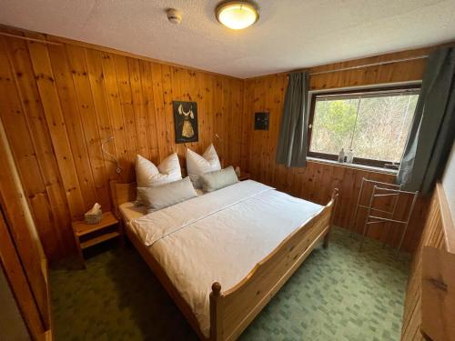 Cette chambre en bois comprend un grand lit. dans l'établissement Häusle in der Tannenmühle, à Seeg