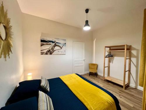 - une chambre dotée d'un lit avec une couverture bleue et jaune dans l'établissement Casa Teyssier #3 - Joli & Paisible T3 - Hyper Centre Brive, à Brive-la-Gaillarde