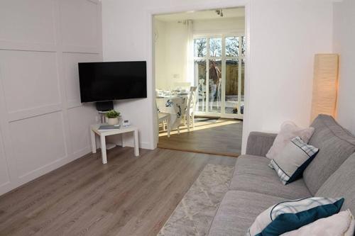 a living room with a couch and a flat screen tv at Lovely 2-Bed House in St Andrews Scotland in St Andrews