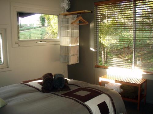 a bedroom with a bed and a window with blinds at Lavandula Country House in Hepburn Springs