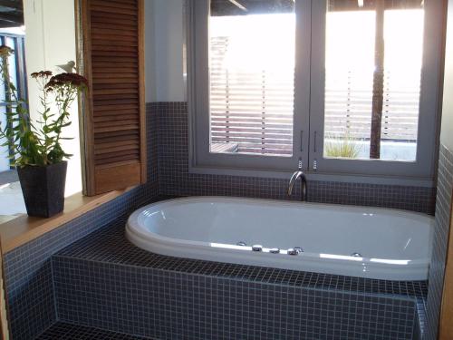 a bath tub in a bathroom with a window at Lavandula Country House in Hepburn Springs