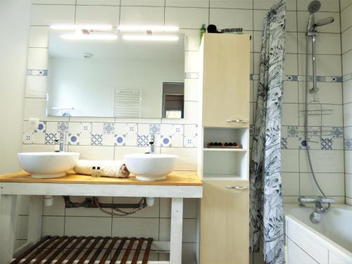 une salle de bain avec deux lavabos, un miroir et une baignoire dans l'établissement *Villa Ivoire* Grand jardin-calme-terrain pétanque, à Messanges