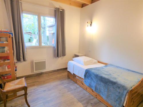 une petite chambre avec un lit et une fenêtre dans l'établissement *Villa Ivoire* Grand jardin-calme-terrain pétanque, à Messanges