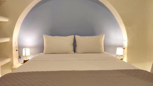 a bed with two pillows and two lamps in a room at Aelia Mare Apartments Nr4 in Istérnia