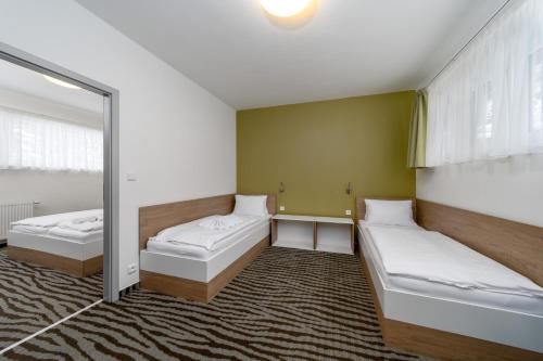two beds in a room with a mirror at Pension Janský Potok II. in Janske Lazne