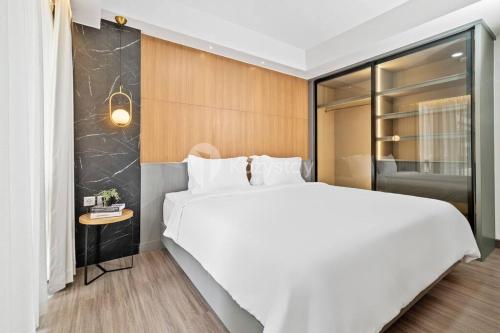 a bedroom with a large white bed and a table at Mahadara by Kozystay Bandung in Bandung