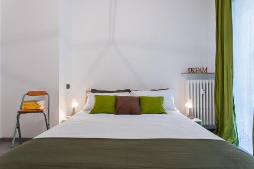 una camera da letto con un grande letto con cuscini verdi di Casa Foà con terrazzo a due passi dal Parco by Wonderful Italy a Torino