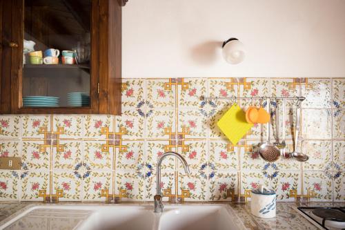 a kitchen with a sink and a tiled wall at Casa Clelia Piazza in Ustica