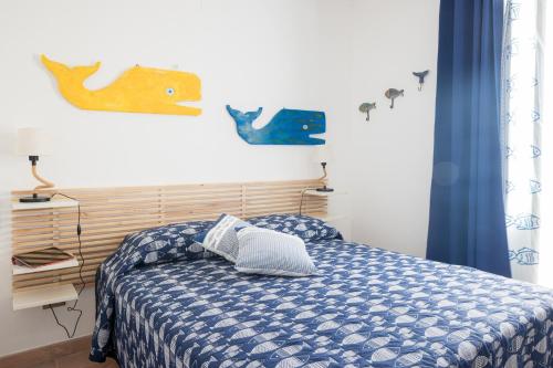 a bedroom with a bed with a blue and white comforter at Casa Clelia Piazza in Ustica