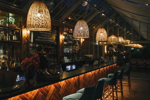 a bar with chairs and chandeliers in a restaurant at Woodlands Cottage, Wynyard Hall in Grindon