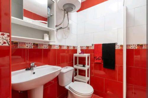 ベナルマデナにあるStudio Agata Residencialの赤と白のバスルーム(トイレ、洗面台付)