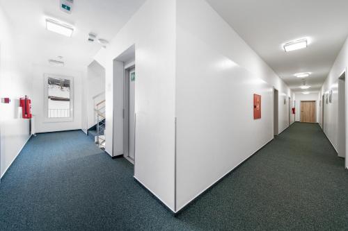 a hallway of an office with white walls and blue carpet at Pension Janský Potok II. in Janske Lazne