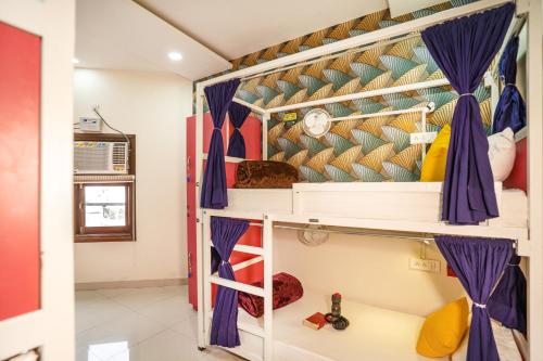 1 dormitorio con 1 litera con cortinas moradas en goSTOPS Amritsar, Chatiwind Gate, en Amritsar