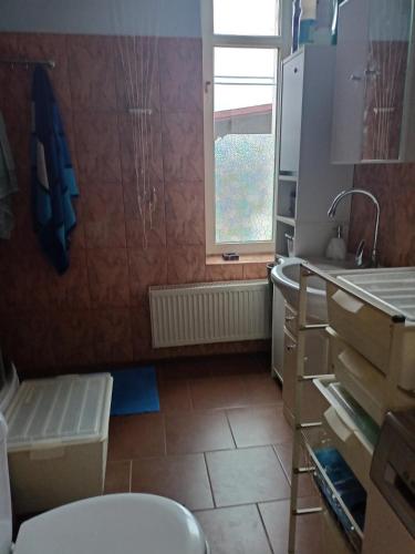 a kitchen with a toilet and a sink and a window at - PASTELOWY loft - in Sopot