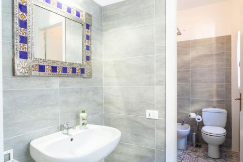 a bathroom with a sink and a toilet and a mirror at Guest House San Pietro in Reggio Emilia