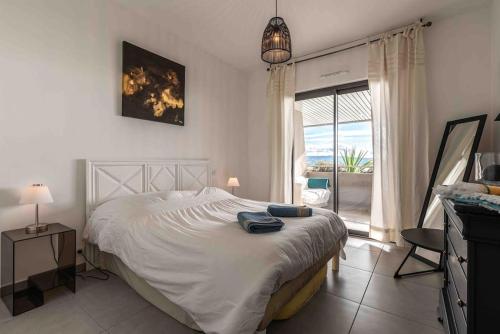 sypialnia z dużym białym łóżkiem i oknem w obiekcie Ajaccio, les Cyclades, magnifique appartement vue mer w Ajaccio