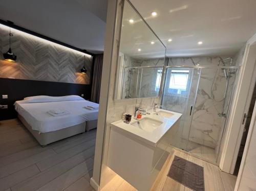 uma casa de banho com um lavatório, um chuveiro e uma cama. em Central Business Suites Nicosia By Platform 357 em Nicósia
