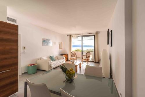un salon avec une table en verre et des chaises dans l'établissement Ajaccio, les Cyclades, magnifique appartement vue mer, à Ajaccio