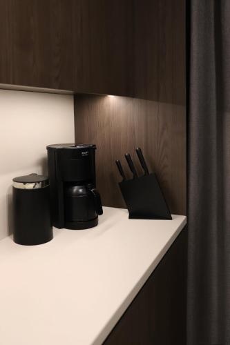 a kitchen counter with a coffee maker and utensils at Apartamenty Legionów- A12 stylowy apartament w świetnej lokalizacji in Kalisz