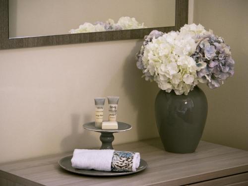 un tavolo con un vaso di fiori e un piatto con un asciugamano di Zula Affittacamere a Firenze