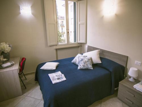 a bedroom with a blue bed with pillows and a window at Zula Affittacamere in Florence