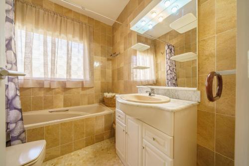 y baño con lavabo, bañera y aseo. en HomeHolidaysRentals Dorada - Costa Barcelona, en Palafolls