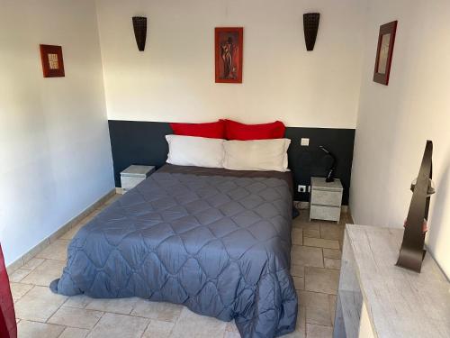 um quarto com uma cama azul e almofadas vermelhas em Le Beauvaisis em Esches