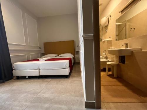 Dormitorio pequeño con cama y lavamanos en Napolit'amo Hotel Principe, en Nápoles