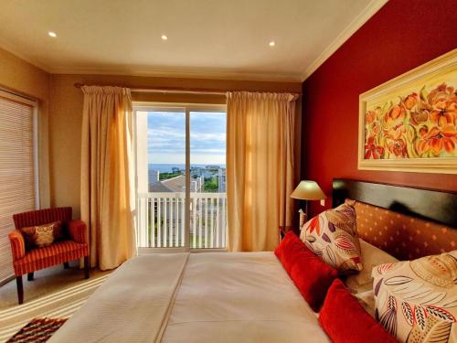 1 dormitorio con cama y ventana grande en Luxury Villa in Pinnacle Point with Inverter en Mossel Bay