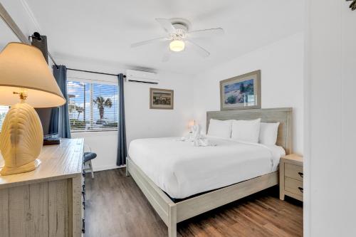 Schlafzimmer mit einem Bett, einem Schreibtisch und einem Fenster in der Unterkunft 2 BR Ocean Forest Villa Steps Away From Pristine Sandy Beaches in Myrtle Beach