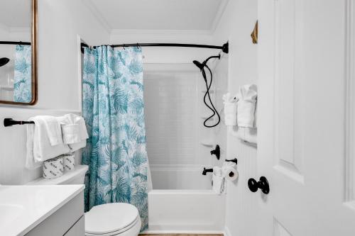a white bathroom with a toilet and a shower at 2 BR Ocean Forest Villa Steps Away From Pristine Sandy Beaches in Myrtle Beach