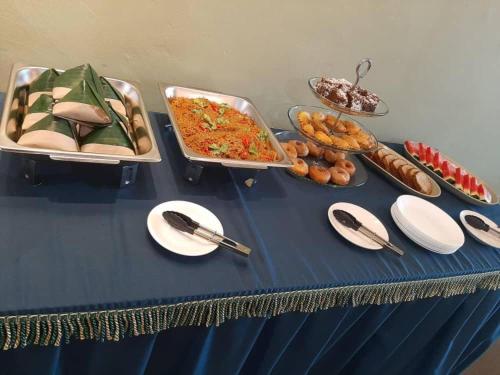 a blue table topped with food and plates of food at SY JERANTUT HOTEL in Jerantut