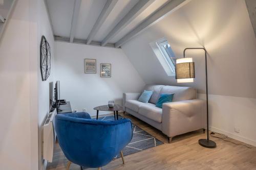 een woonkamer met een bank en een blauw bad bij Charmant appartement en plein centre du Pouliguen! in Le Pouliguen