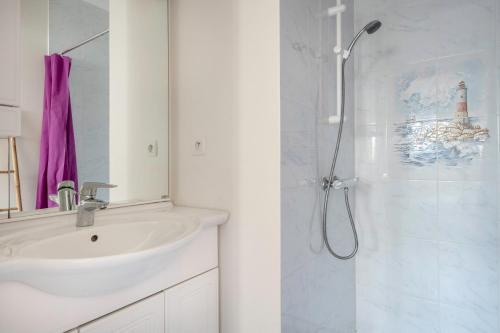 a white bathroom with a sink and a shower at Maison lumineuse, pour 8, avec vue sur mer in Saint-Gildas-de-Rhuys