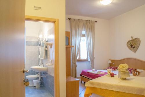 a bedroom with two beds and a bathroom with a sink at Antica Residenza de Poda in Flavon