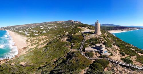 an island with a lighthouse on top of it next to the ocean at Villa Alkaram de lujo con vistas panorámicas al mar in Zahara de los Atunes