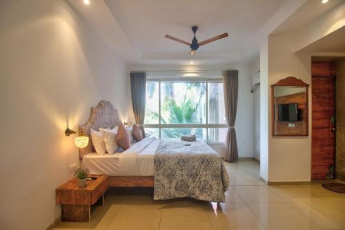 a bedroom with a bed and a large window at Sea Sapphire in Calangute