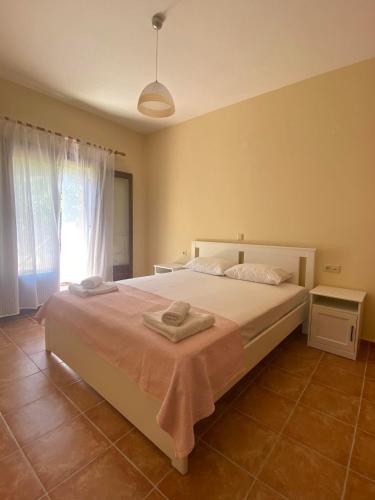 sypialnia z dużym białym łóżkiem i oknem w obiekcie Luna Bay w mieście Agios Ioannis Pelio